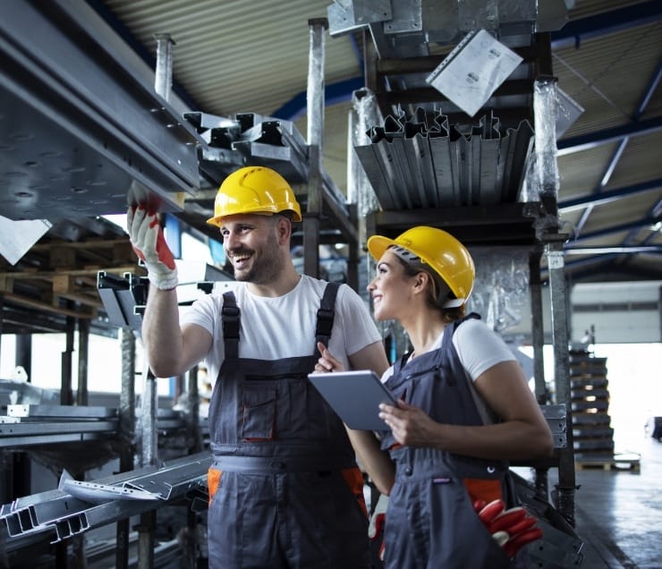 factory workers checking inventory with tablet computer industrial warehouse full metal parts